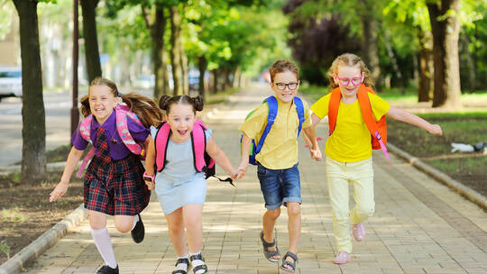small schoolchildren with colorful school bags and backpacks run to school.