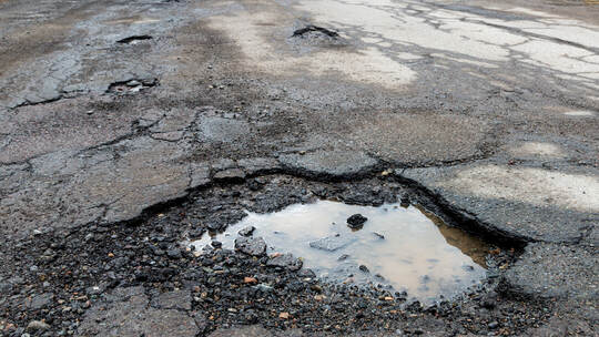 Potholes On A Paved Road