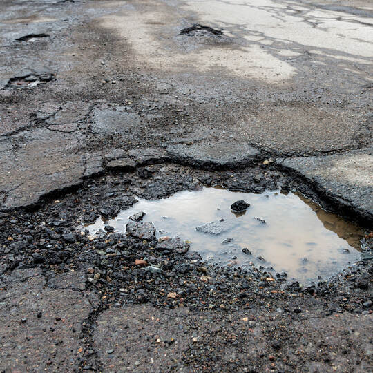 Potholes On A Paved Road