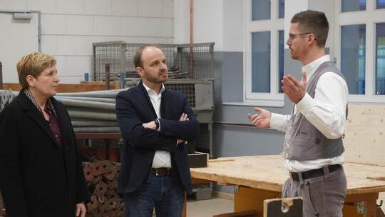 Bauministerin Nicole Razavi und Landtagskandidat Andreas Renner lassen sich von Ausbildungsmeister Fabian Bartz (rechts) die übe