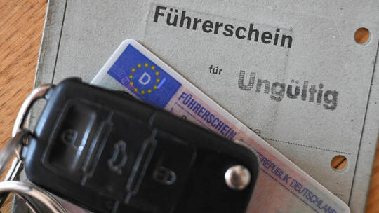 Ein Autoschlüssel liegt auf zwei Führerscheinen