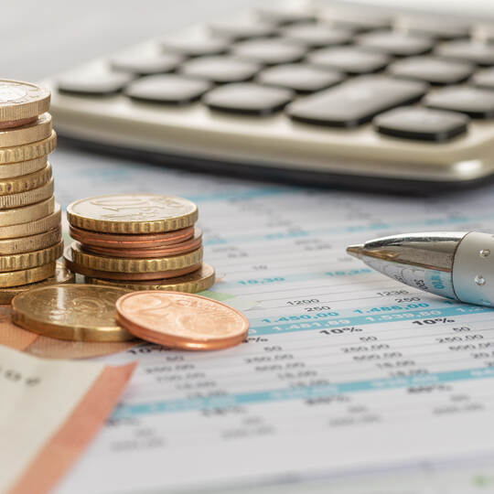 Geld mit Taschenrechner und Kugelschreiber