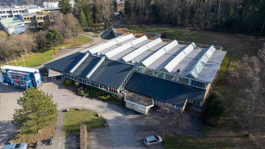 Die Stadtverwaltung möchte die Holzpaneele an der Fassade der Neuenbürger Stadthalle streichenlassen. Dagegen gibt es aber merkl Stadthalle Neuenbürg Drohne