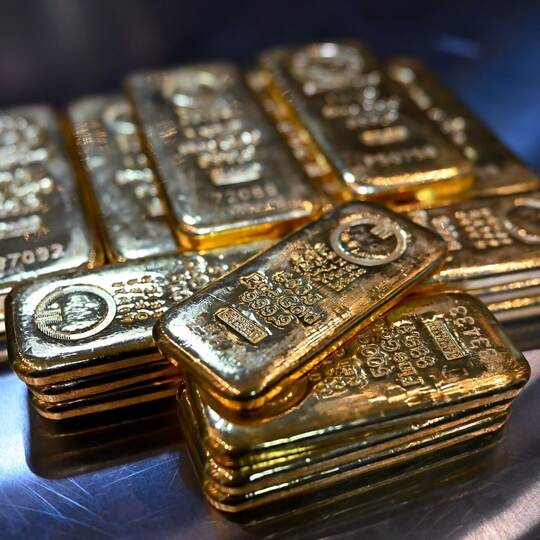 Goldbarren liegen in einem Tresor auf einem Tisch