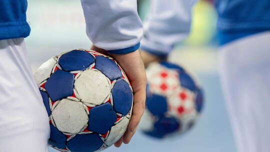 Handball players holding balls for handball