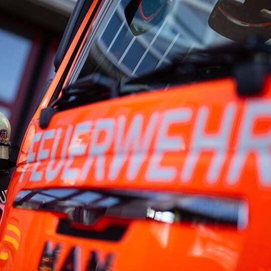 Feuerwehrmann steht neben einem Feuerwehrauto (Symbolbild)