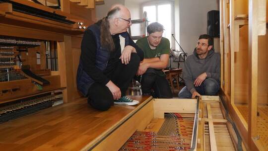Organist Roman Rothen (links) hört den beiden Orgelbauern Bastian van Vliez und Mathias Moßman gespannt zu, als sie ihm erklären