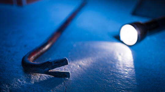 Symbolbild Einbruch, Taschenlampe mit Brechstange