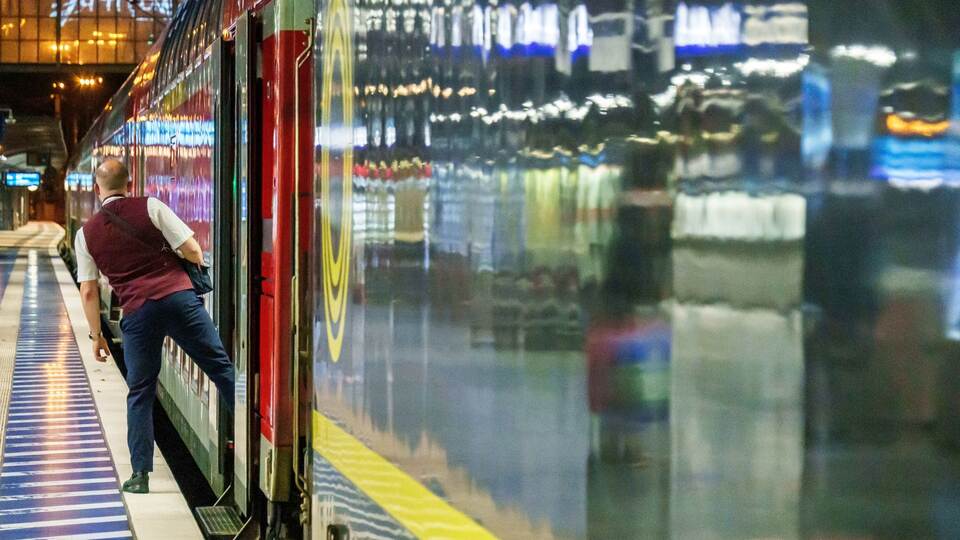 Ein Zugbegleiter blickt kurz vor Abfahrt zum Lokführer.