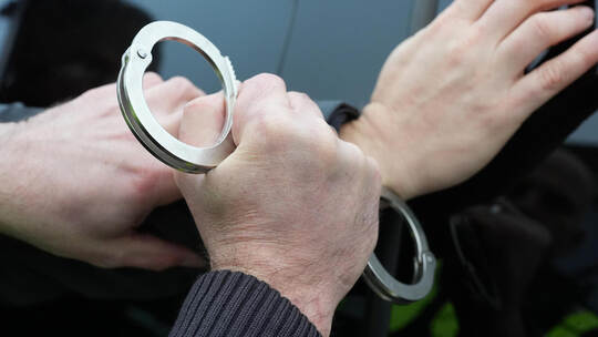 Polizist stellt eine Verhaftung nach. Im Fall des Geldabholers der Anlagebetrüger haben die Handschellen in Mühlacker geklickt. Festnahme Symbolbild