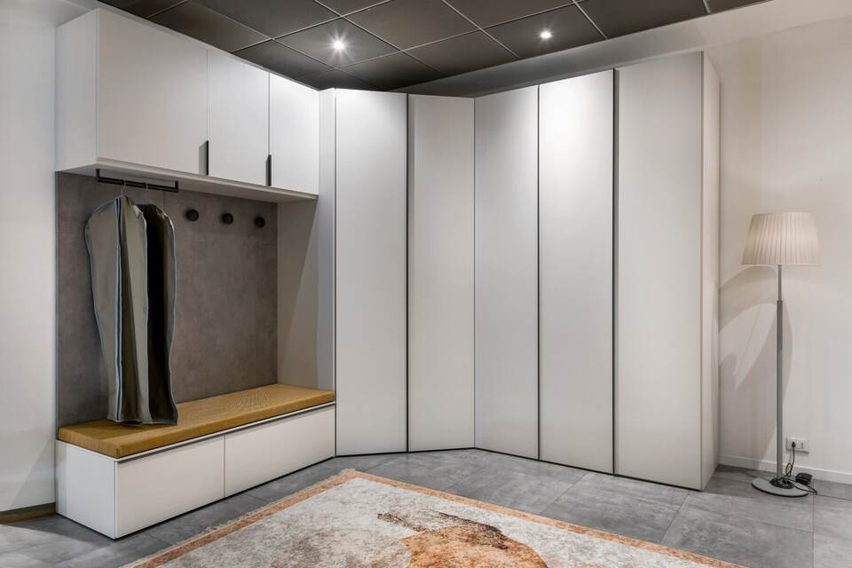 Interior of stylish spacious wardrobe room and wooden cupboards in light