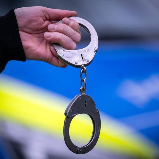 Festnahme an einem Polizeiwagen
