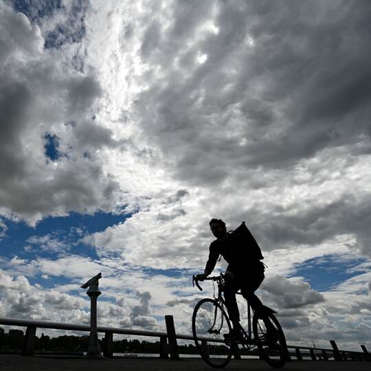 Radfahrer unter Wolkenhimmel