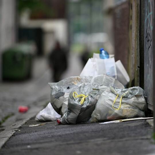 Müllsäcke und Abfall auf einem Gehweg