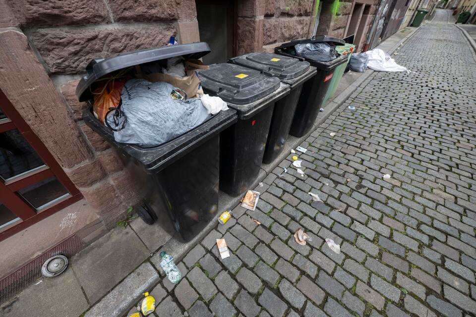 Überquellende Mülltonnen und Abfall in Gasse Überquellende Mülltonnen und Abfall in Gasse