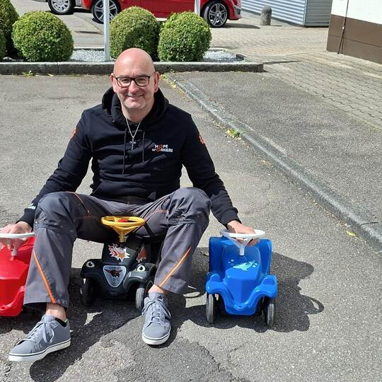 Pastor Jochen Lengler wirbt mit mehreren Bobbycars für den geplanten Weltrekordversuch der Hope Workers im Kurpark Bad Wildbad.