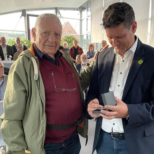 Bürgermeister Matthias Stepan übergibt die silberne Münze an Wolfgang Obert.