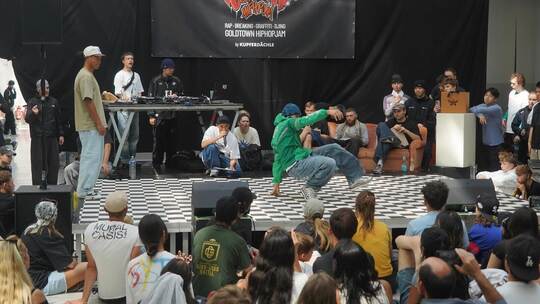 Auf einer großen Bühne duellieren sich die B-Boys und B-Girls im Breakdance. Die drei Judges entscheiden, wer die nächste Runde