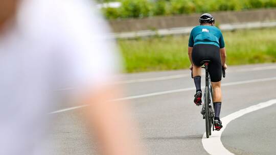 Ein Radfahrer fährt in der Sonne auf seinem Rennrad