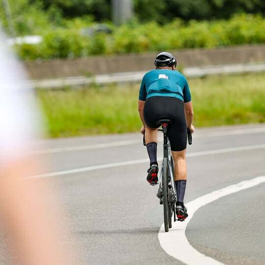Ein Radfahrer fährt in der Sonne auf seinem Rennrad