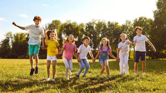 Ein hoher Kinderanteil bringt für Gemeinden auch Herausforderungen mit sich. Studio Romantic - stock.adobe.com Group of a happy smiling kids friends having fun and jumping in the park standing in a line.