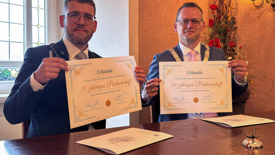 Schmöllns Bürgermeister Sven Schrade (links) und Mühlackers Oberbürgermeister Stephan Retter zeigen die Urkunde zur Städtepartne