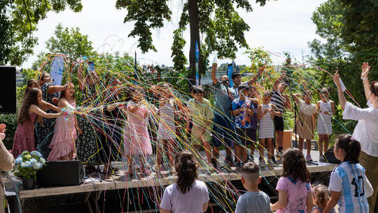 Mit einem gemeinsamen Lied und viel Konfetti eröffnen die Kinder des Lukaszentrums das bunte Fest. Röhr
