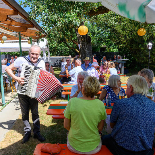 Beste Stimmung beim Gartenfest: Musiker Hans Pfeil spielt mit seinem Akkordeon Wunschlieder der Gäste.