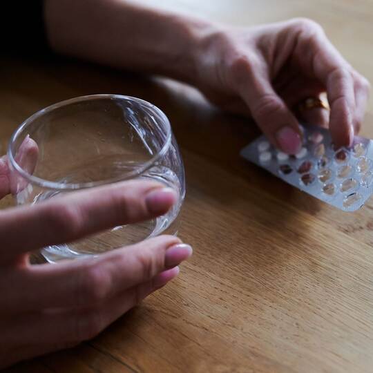 Frau hält Tabletten in der Hand