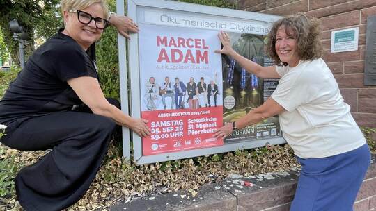 Pfarrerin Heike Reisner-Baral (links) und Projekt-Managerin Andrea Pfrommer stellen die Plakate für das neue Halbjahresprogramm