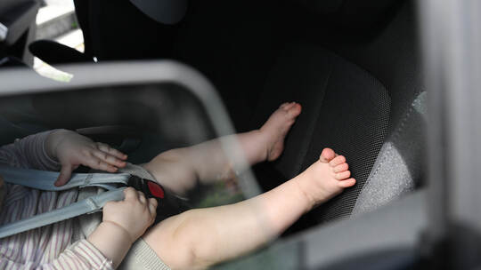 Baby liegt in einer Babyschale im Auto