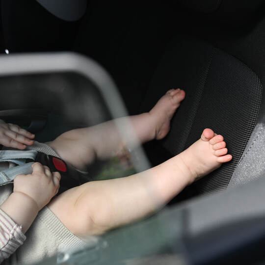 Baby liegt in einer Babyschale im Auto