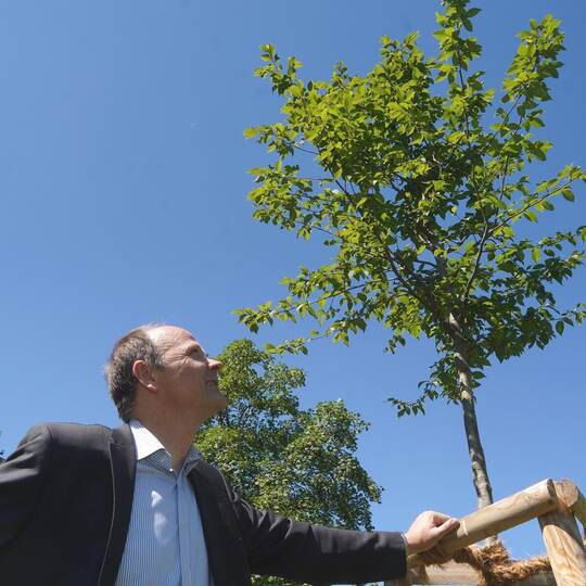Direktor Hartmut Westje-Bachmann steht an dem Denkmal, das sich die Königsbacher Abiturienten auf dem Schulhof gesetzt haben. Es