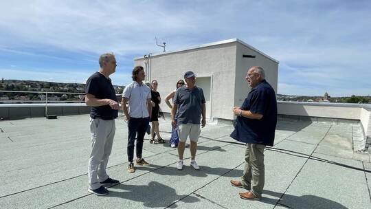 Auf dem Dach des ehemaligen Retourengebäudes an der Maxi 50. Bader-Projektingenieur Claus Neumann (rechts) erklärt der Jury der