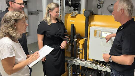Diese gelbe Maschine ist eine Absorptionskälteanlage. Wie sie funktioniert, erklärt Energieexperte Jochen Hüttler (rechts) den i