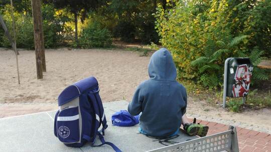 Viele Gründe, viele Ansätze für Lösungen: Die Stadt Pforzheim geht mit Sanktionen gegen Schulschwänzen vor, aber auch mit pädago Kind mit Schulranzen auf Spielplatz