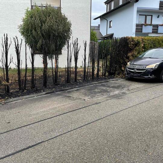 Vom Feuer versehrt sind die Hecken und der Corsa, der hinter dem ausgebrannten Smart geparkt hat. Am Montagabend wird die Feuerw