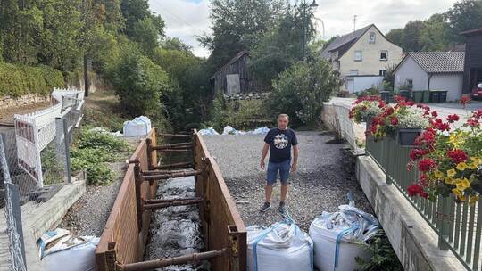 An der Glattbachbrücke zeigt Zeljko Schuhmacher auf das Provisorium, das seit März 2025 den Uferhang sichert. Dem Stadtrat dauer
