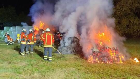 Flammen schlagen am Mittwochabend bei Dietenhausen aus Heu- und Silageballen. Kelterns Feuerwehr löscht stundenlang, aber erfolg