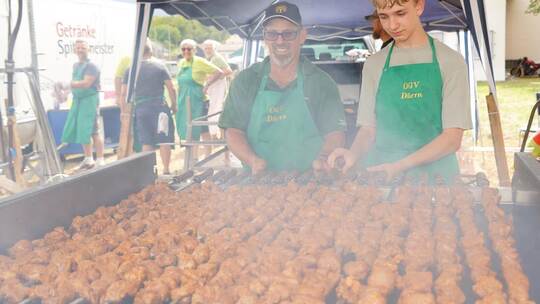 Friedemann Funk kümmert sich um den Spießbraten und freut sich über die tatkräftige Unterstützung junger Vereinsmitglieder. Nebe