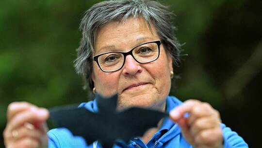 Susanne Brückner vom Nabu Neuhausen hält eine Schablone hoch, die zeigt, wie groß die Zwergfledermaus ist, auf deren Spuren die