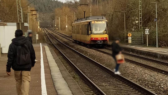 Die S5 verlässt den Bahnhof Ersingen Richtung Pforzheim. Nur unmittelbar danach huscht ein Mann über die Gleise, um auf die ande