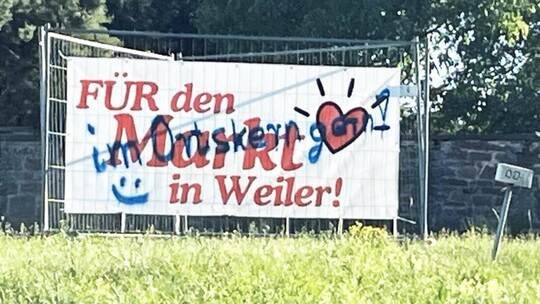 Pro und kontra Supermarkt auf einem Banner. Mit dem Übermalen möchte die Bürgerinitiative „Hofacker Weiler“ allerdings nichts zu