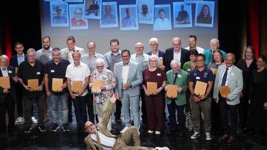 Kulturbürgermeister Tobias Volle (Mitte, blauer Anzug) würdigt die Geehrten, Entertainer Peter Jagusch liegt ihnen gar zu Füßen.