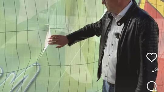 Oberbürgermeister Stephan Retter zeigt in einem Video in den sozialen Medien auf einen Riss in einem der Street-Art-Banner am Mü