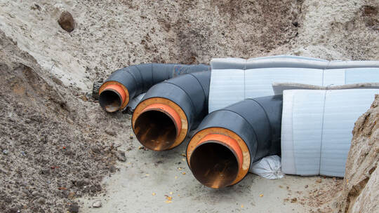 Insulated district heating pipes installation in deep urban trench