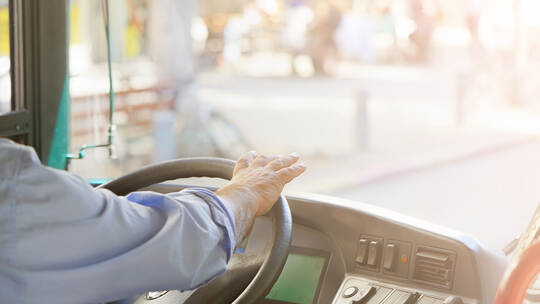 cropped shot of bus driver holding steering whee