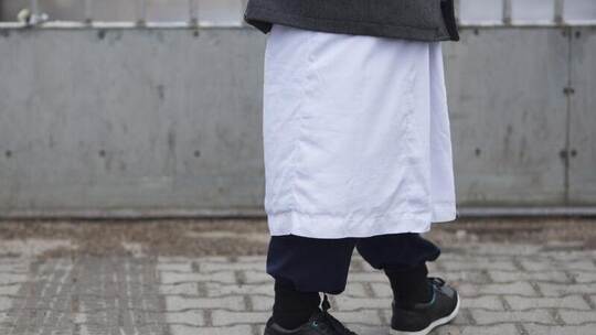 Ein Mann in traditioneller Bekleidung steht vor einem Versammlungsort der Salafisten in Berlin. Foto: Florian Schuh/dpa