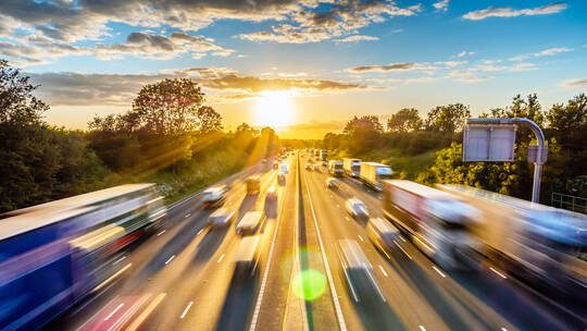 heavy traffic moving at speed on UK motorway in England at sunset