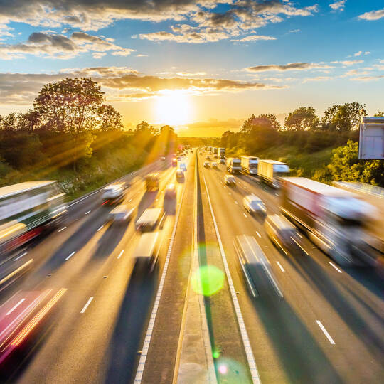 heavy traffic moving at speed on UK motorway in England at sunset